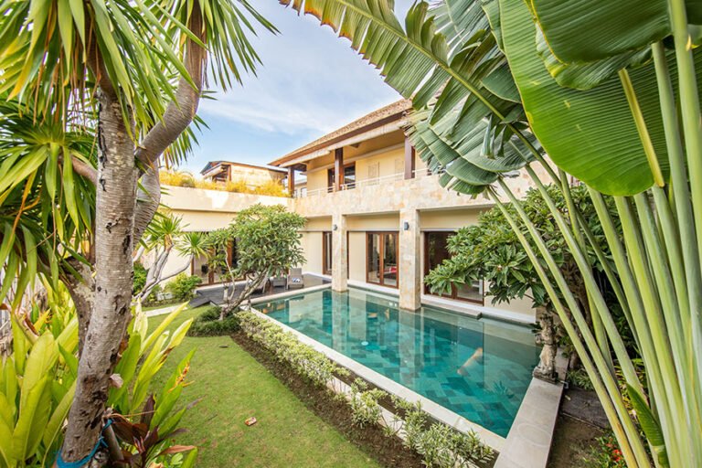 una casa muy grande con Alberca y plantas Verdes a su alrededor