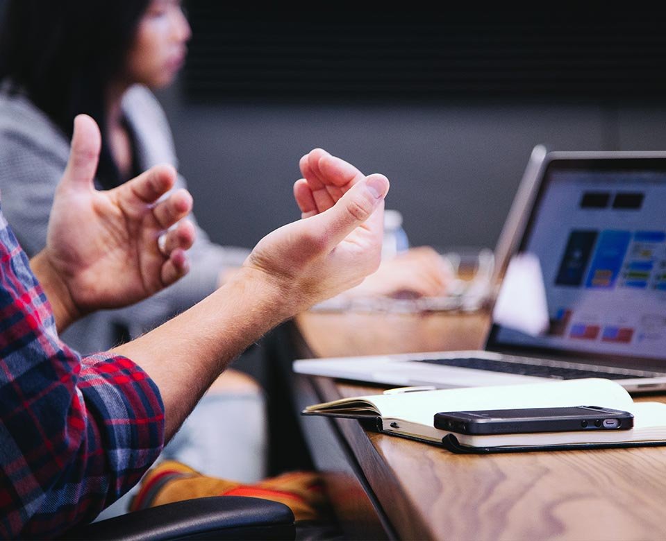 una persona con una computadora sobre UN escritorio explicando un tema de comercializacion para propietarios