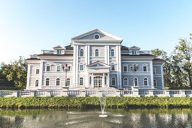 Casa de color Gris de tres pisos con una fuente al frente